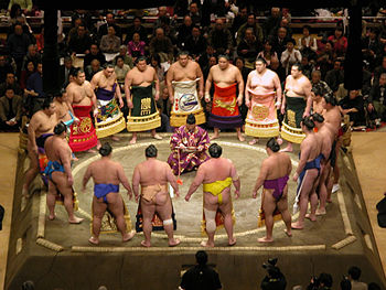 Sumo wrestlers gather in a circle around the gyoji (Referee) in the dohyō-iri (ring-entering ceremony).