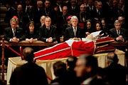 Clinton, along with George W. Bush, Laura Bush, George H. W. Bush, Condoleezza Rice, and Andrew Card pay their respects to Pope John Paul II before the pope's funeral.