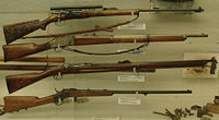 A collection of rifles from the Fram museum, a civilian Krag-Jørgensen M1894 with a carved stock on top.