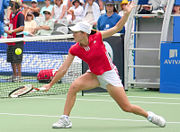 Justine Henin performing a backhand volley.