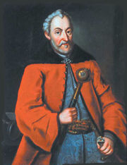 Kanclerz and Grand Hetman Jan Zamoyski herbu Jelita, in crimson delia and blue silk żupan. Holds hetman's baton (buława hetmańska)