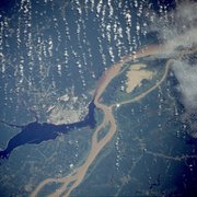 Manaus, the largest city on the Amazon, as seen from a NASA satellite image, surrounded by the muddy Amazon River and the dark Rio Negro.