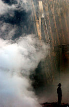 A solitary firefighter stands amid the rubble and smoke in New York City