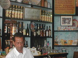 Bartender at the famous La Bodeguita del Medio in Havana. Hanging on the bar is a plate with a likeness of Ernest Hemingway and a framed, signed message written by him. He was a regular patron.