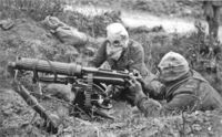 British Vickers machine gun crew wearing PH gas helmets with exhaust tubes.
