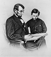 An 1864 Mathew Brady photo depicts President Lincoln reading a book with his youngest son, Tad