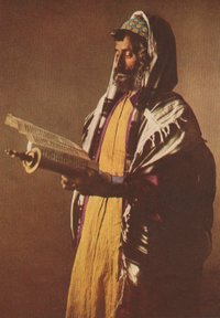 A Yemenite Jew at morning prayers, wearing a kippah skullcap, prayer shawl and tefillin.
