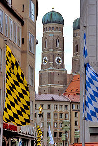 Banners with the colours of Bavaria (right) and Munich (left) with the Frauenkirche in the background.