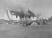 One British response to the guerrila war was a 'scorched earth' policy to deny the guerillas supplies and refuge. In this image Boer civilians watch their house as it is burned.