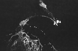 Hiei, trailing oil, is bombed by U.S. B-17 bombers from high altitude north of Savo Island on November 13, 1942.
