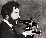 Bell speaking into prototype model of the telephone
