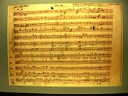 A sheet of music from the Dies Irae movement of the Requiem Mass in D Minor (K. 626) in Mozart's own handwriting. It is located at Mozarthaus in Vienna, Austria.