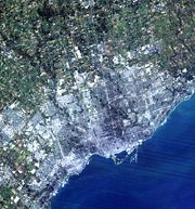 A simulated-colour image of Toronto taken by NASA's Landsat 7 satellite from 1985. Yonge Street can clearly be seen bisecting the city just right of centre in the image, the other prominent road, running east-west, is Highway 401.