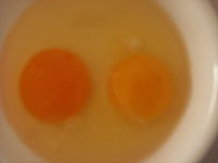 A free range egg (left) next to a battery egg (right).