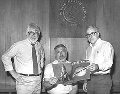 This 1980 photograph, taken at the CDC, shows three former directors of the Global Smallpox Eradication Program as they read the news that smallpox had been globally eradicated.