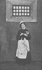 Pankhurst (wearing prison clothes) described her first incarceration as "like a human being in the process of being turned into a wild beast".
