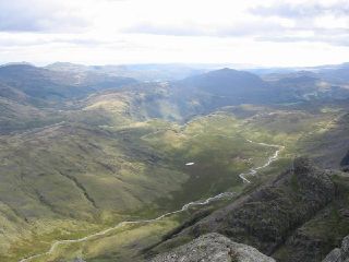 The panorama across Eskdale from Ill Crag. Harter Fell and Hard Knott can be seen, also a small tarn.