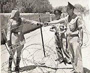 Israeli policemen meet a Jordanian Legionnaire near the Mandelbaum Gate.