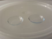 A pair of contact lenses, positioned with the concave side facing upward.