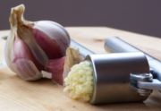 Garlic being crushed using a garlic press.