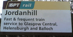 The name sign identifying Jordanhill station. The sign highlights the primary destinations: Glasgow Central, Helensburgh, and Balloch.