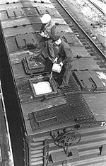 Workmen top off a reefer's top-mounted bunkers with crushed ice.