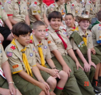 Boy Scouts at a campfire ring at summer camp