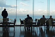 Men relaxing in a cafe overlooking the Mediterranean Sea in Tel Aviv, Israel.