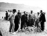 Gen. Leslie R. Groves, Oppenheimer,  and others at remains of the Trinity shot tower a few weeks later.