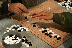 A pair of Shanghaiese men demonstrate the traditional technique of holding a stone.